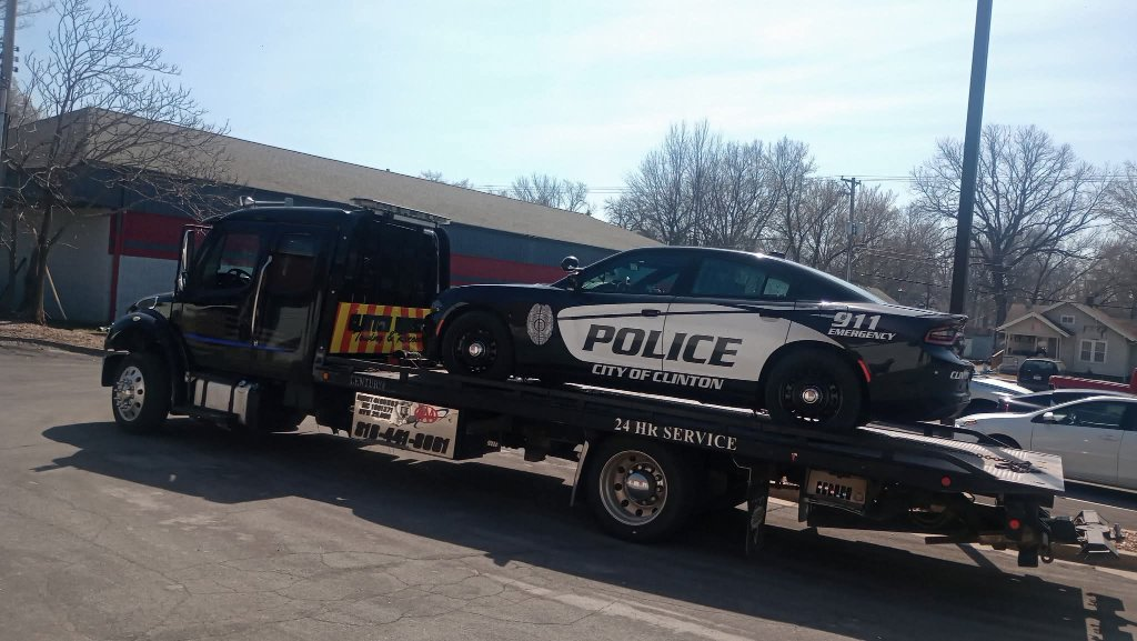 Clinton Wrecker flatbed transporting a vehicle